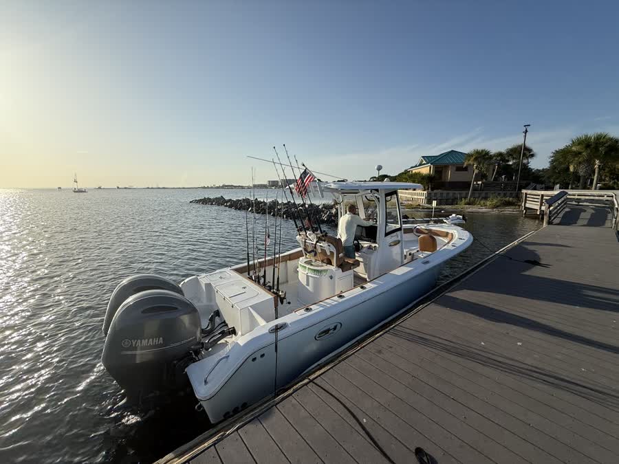 Big Fish Energy charter boat docked, showing the twin outboard engines and cockpit layout