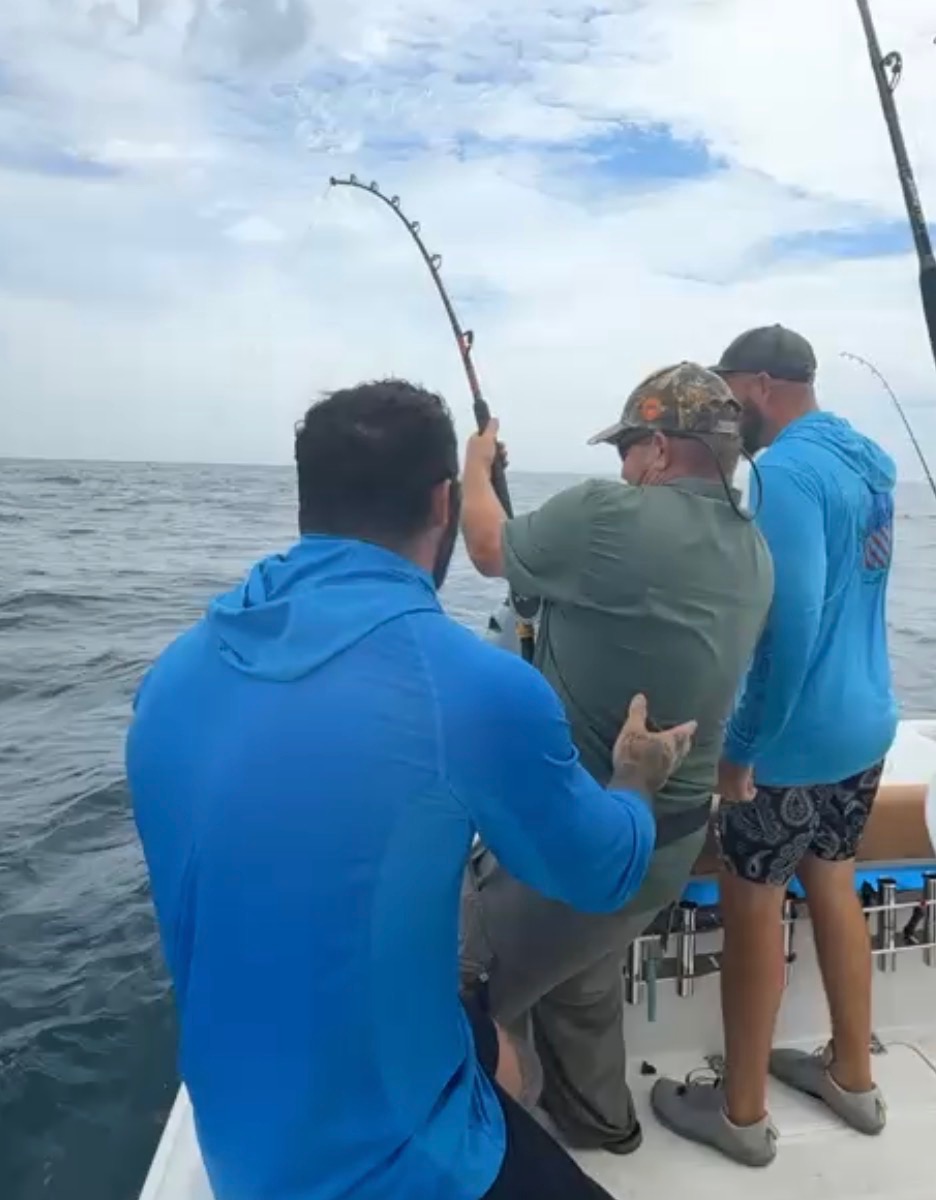 Guests working together to land a fish on a Big Fish Energy 3/4 day offshore trip