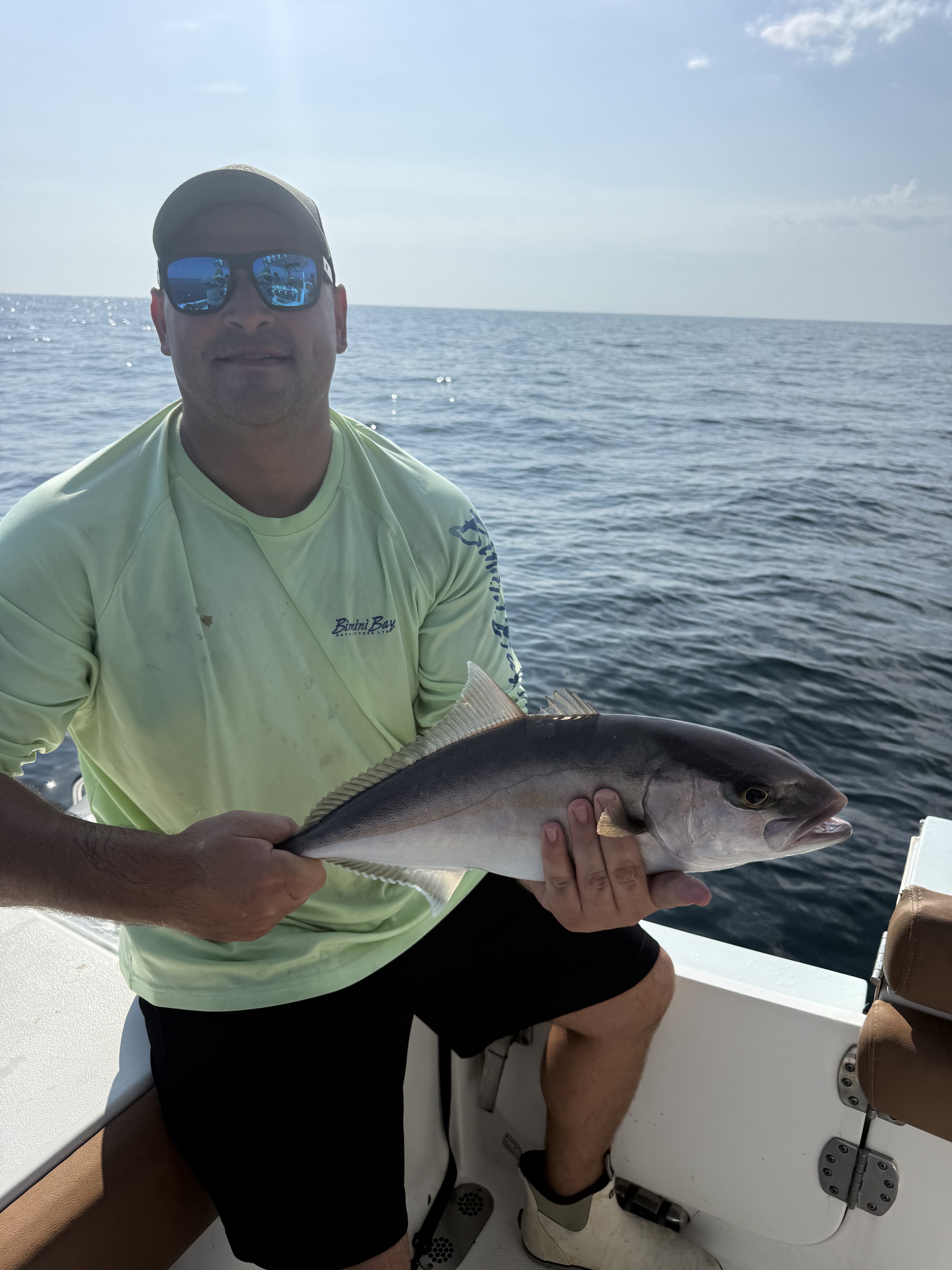 A customer holding an amberjack catch aboard the Big Fish Energy charter boat