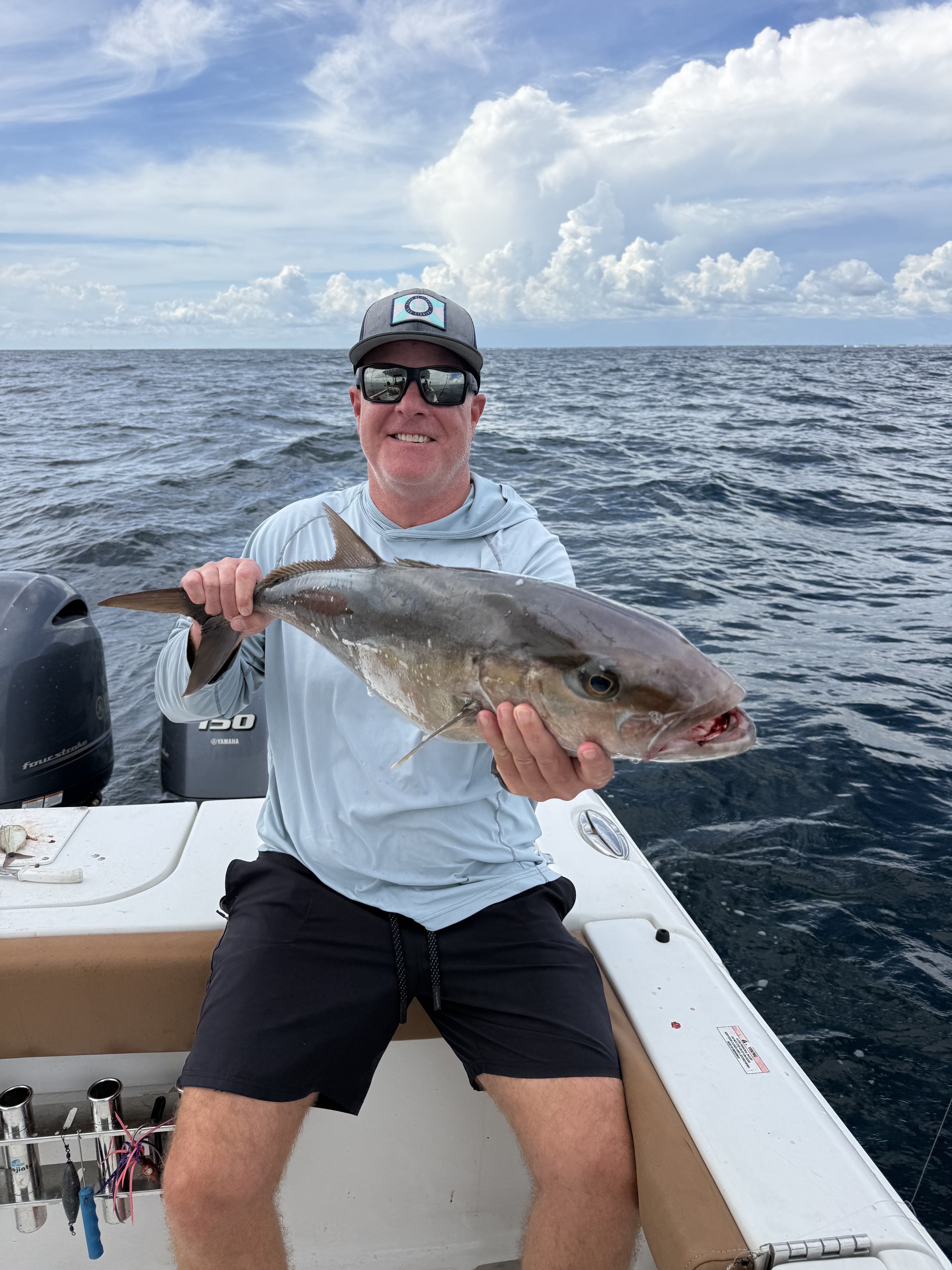 A customer holding a big amberjack catch aboard the Big Fish Energy charter boat
