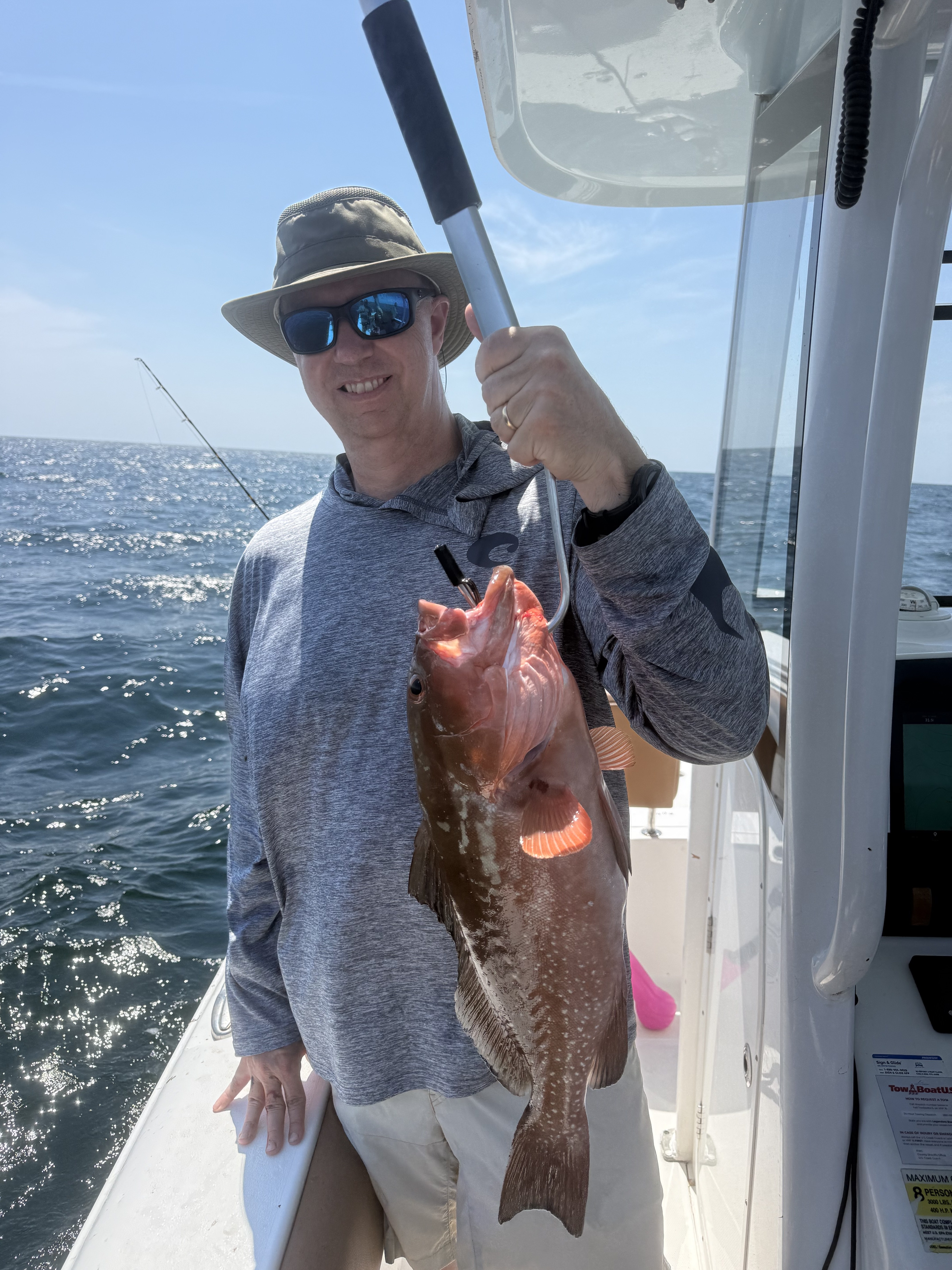 A customer holding a nice red grouper catch aboard the Big Fish Energy charter boat